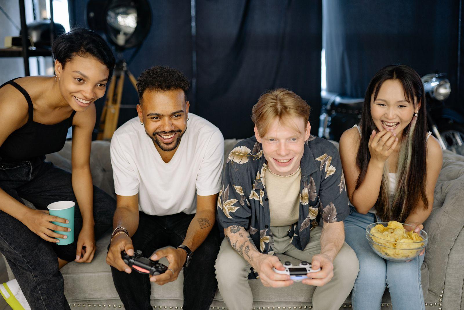 Nhóm bạn ở chung cùng chơi game trên sofa