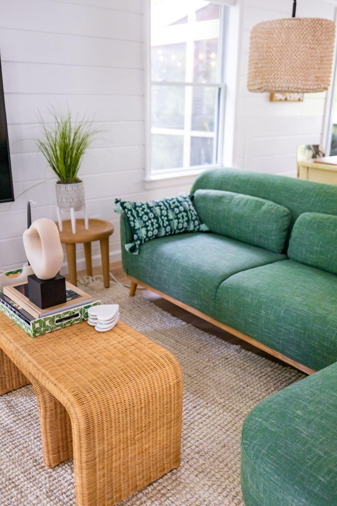 Sofa xanh lá và bàn mây trong phòng khách sáng